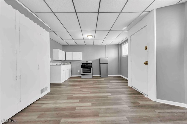 kitchen featuring visible vents, a drop ceiling, appliances with stainless steel finishes, light wood-style floors, and white cabinets