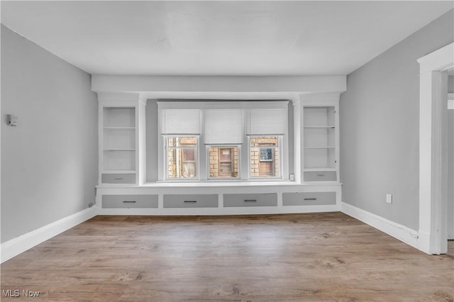 unfurnished room with wood finished floors and baseboards