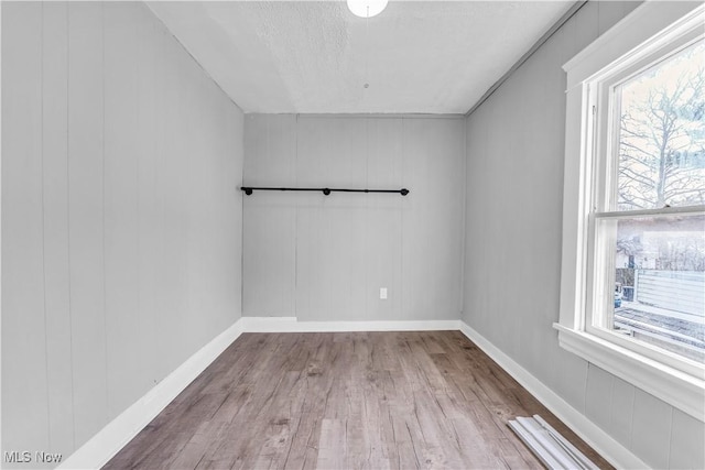 spare room featuring wood finished floors and baseboards