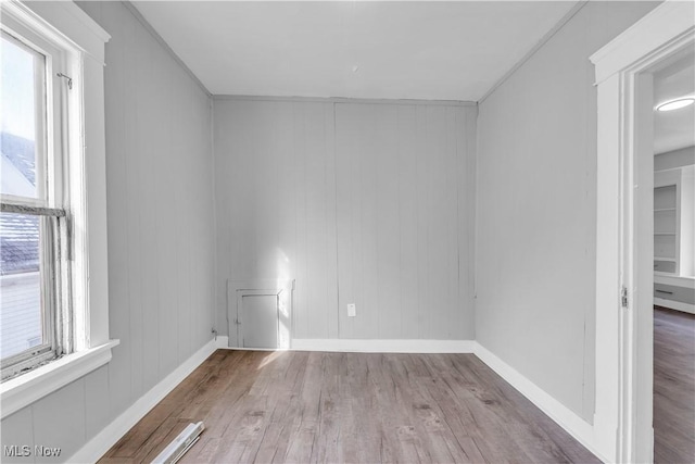 spare room featuring wood finished floors and baseboards