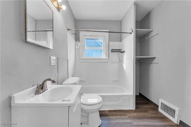 bathroom with vanity, wood finished floors, washtub / shower combination, visible vents, and toilet