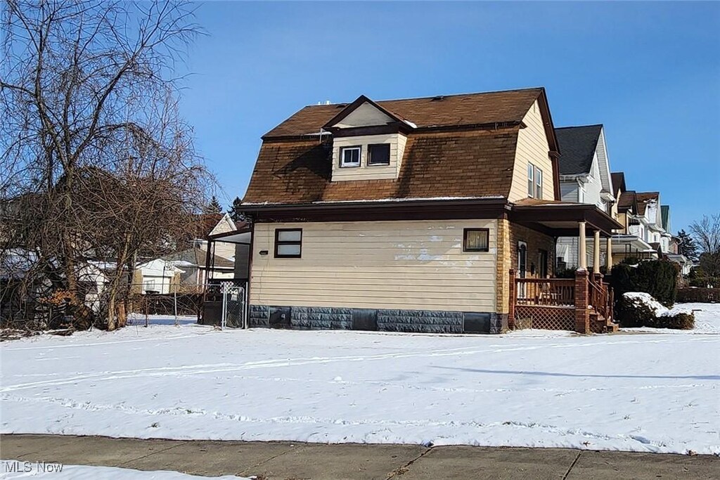 snow covered property featuring a gambrel roof