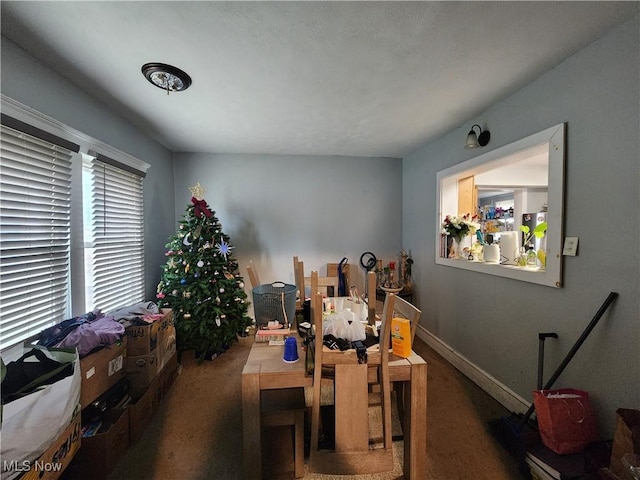 carpeted dining area featuring baseboards