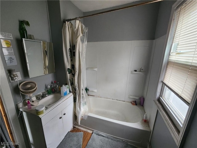 bathroom featuring plenty of natural light, vanity, shower / tub combo, and wood finished floors