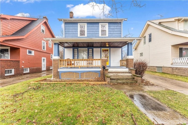 rear view of property featuring a porch and a lawn