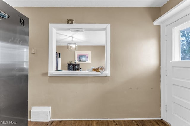 foyer entrance featuring visible vents, baseboards, and wood finished floors