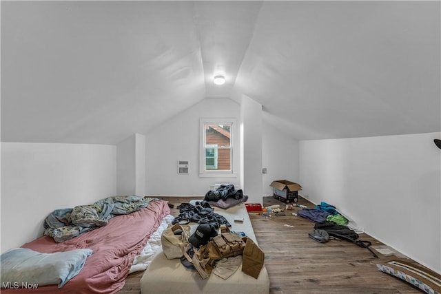 bedroom with vaulted ceiling and wood finished floors