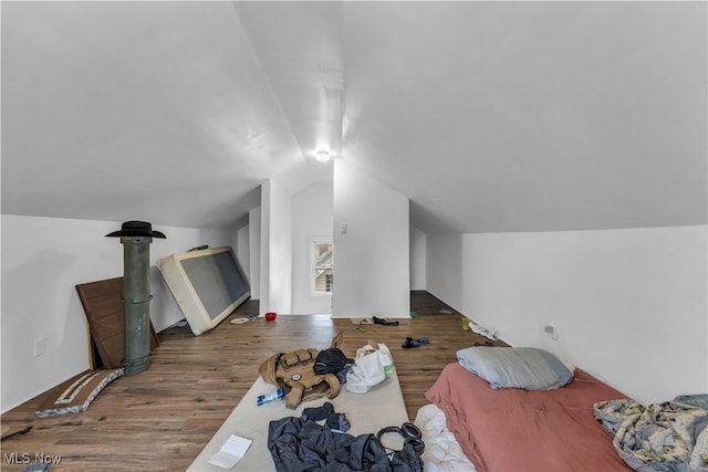 bedroom featuring wood finished floors and vaulted ceiling