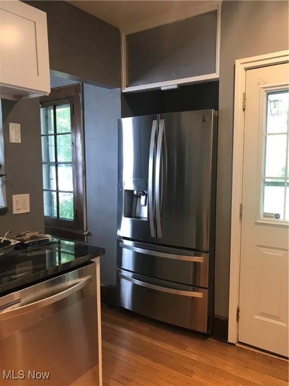 kitchen with light wood-style flooring, white cabinets, and appliances with stainless steel finishes