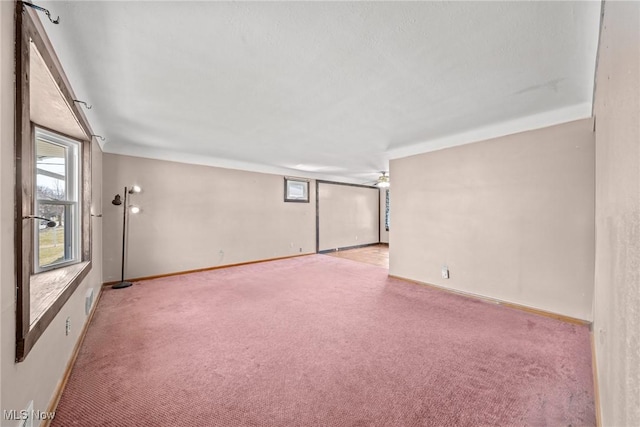 unfurnished room with baseboards and light carpet