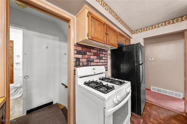 kitchen featuring visible vents, backsplash, baseboards, gas range gas stove, and brown cabinets