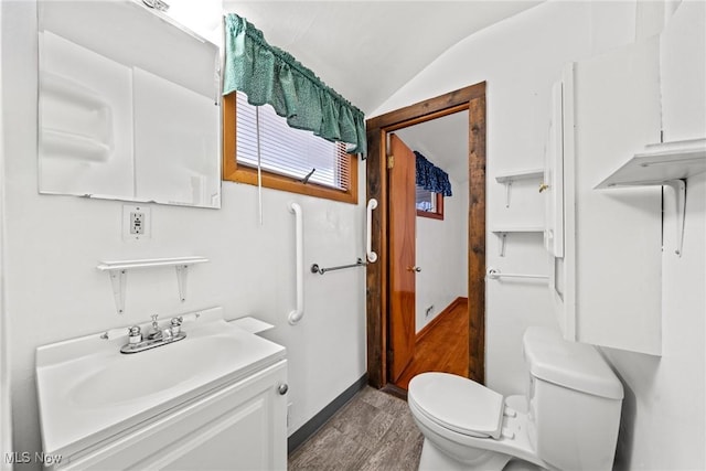 half bath with toilet, vanity, and vaulted ceiling