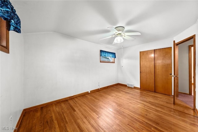 unfurnished bedroom with baseboards, light wood-type flooring, and a closet