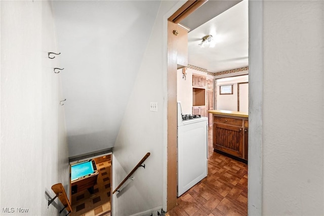 hallway with washer / clothes dryer and an upstairs landing