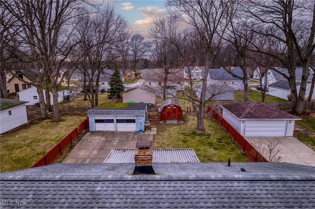 view of front of house featuring a garage, an outbuilding, a front lawn, and fence