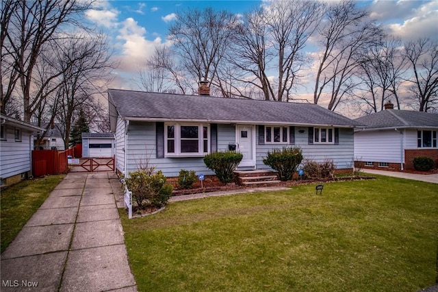 view of front of home featuring fence, a lawn, a chimney, and a shingled roof