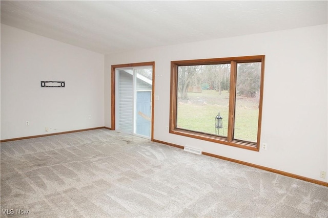 unfurnished room featuring baseboards, visible vents, and light colored carpet