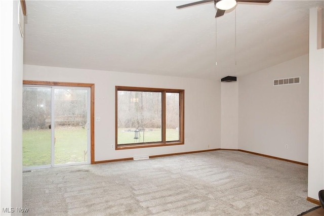 carpeted spare room featuring ceiling fan, baseboards, and visible vents