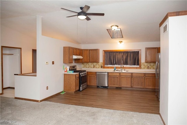 kitchen featuring brown cabinets, under cabinet range hood, visible vents, a sink, and appliances with stainless steel finishes