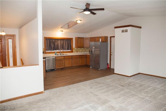 kitchen with stainless steel appliances, a sink, visible vents, carpet, and ceiling fan