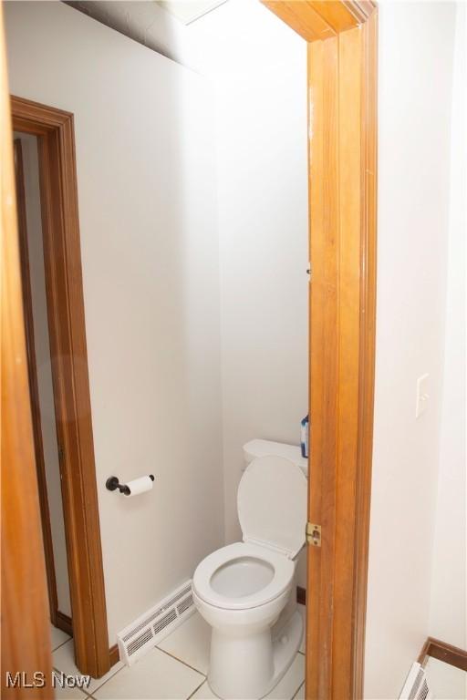 bathroom featuring visible vents, toilet, baseboards, and tile patterned floors