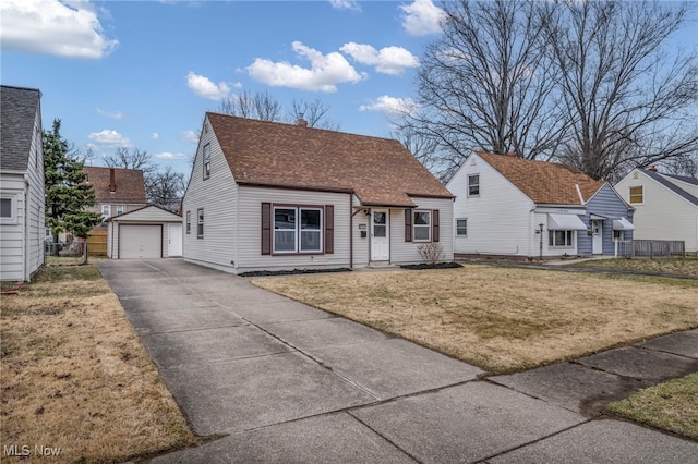 view of front facade with a front lawn, driveway, a detached garage, fence, and an outdoor structure