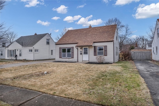 view of front of property with a front lawn, a chimney, and a shingled roof