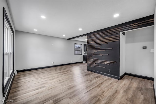 empty room featuring recessed lighting, baseboards, and wood finished floors