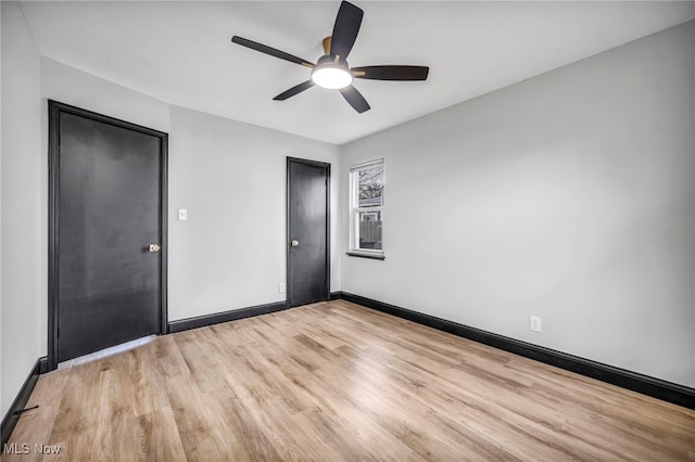 unfurnished room featuring baseboards, light wood-style floors, and a ceiling fan