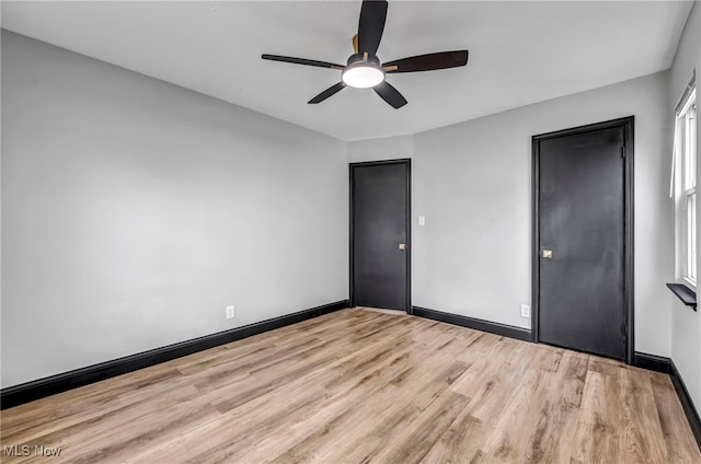 unfurnished bedroom featuring ceiling fan, baseboards, and light wood-style flooring