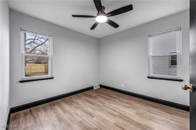 unfurnished room featuring light wood finished floors, visible vents, a ceiling fan, and baseboards