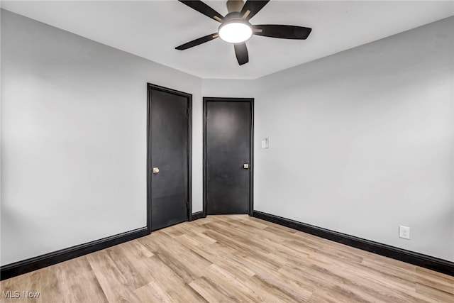 unfurnished bedroom with a ceiling fan, light wood-style floors, and baseboards