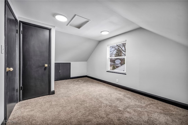 additional living space featuring baseboards, carpet, and vaulted ceiling