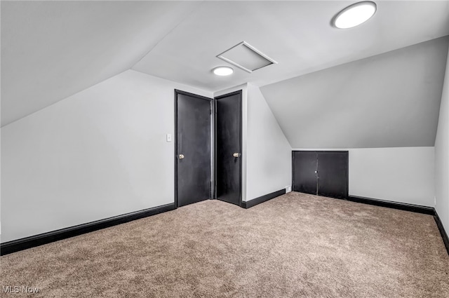 bonus room featuring baseboards, attic access, carpet, and vaulted ceiling