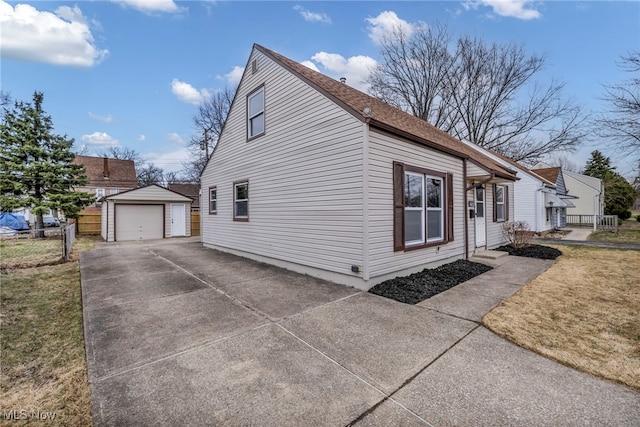 view of side of home with fence, driveway, an outdoor structure, a detached garage, and a lawn