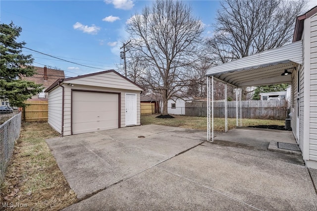 detached garage with concrete driveway and fence