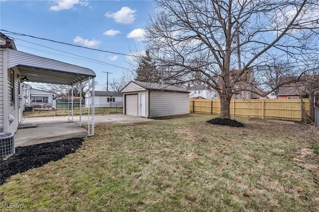 view of yard featuring a garage, a patio area, an outdoor structure, and fence