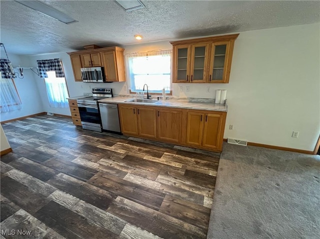 50055 Carroll Rd, East Liverpool, OH 43920 - kitchen with brown cabinetry, visible vents, stainless steel appliances, a sink, and glass insert cabinets