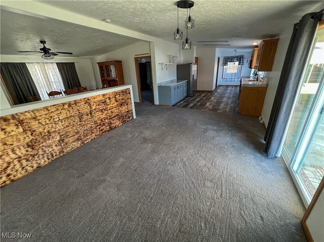 50055 Carroll Rd, East Liverpool, OH 43920 - unfurnished living room featuring dark carpet, a textured ceiling, lofted ceiling, and a sink