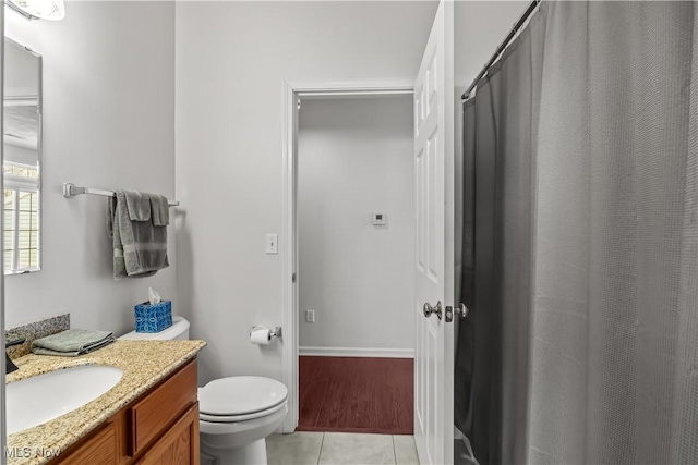 bathroom featuring vanity, a shower with shower curtain, baseboards, tile patterned flooring, and toilet