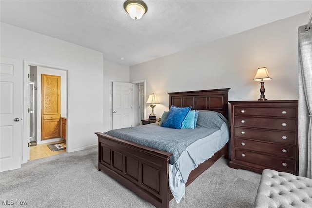 bedroom featuring ensuite bath and light colored carpet