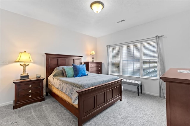 bedroom with light carpet, visible vents, and baseboards