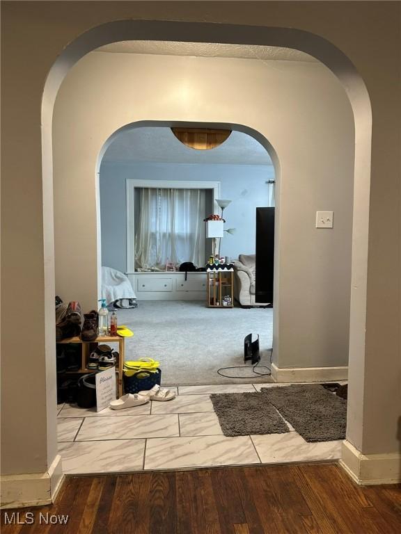 174 Colony Cres, Akron, OH 44305 - hall featuring arched walkways, wood finished floors, and baseboards