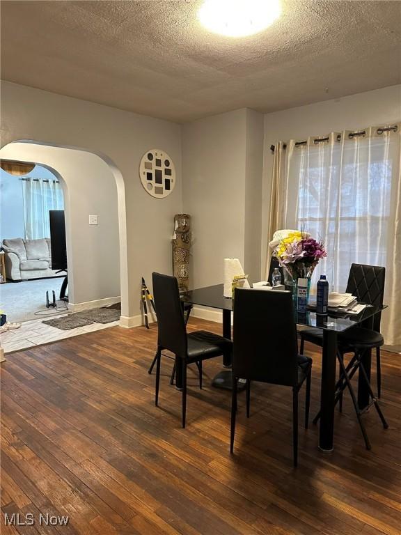 174 Colony Cres, Akron, OH 44305 - dining room with arched walkways, hardwood / wood-style flooring, a textured ceiling, plenty of natural light, and baseboards