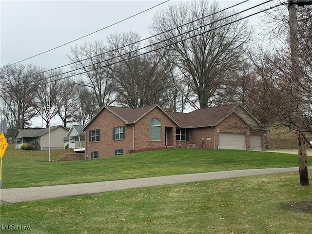 view of front facade featuring brick siding, an attached garage, concrete driveway, and a front yard