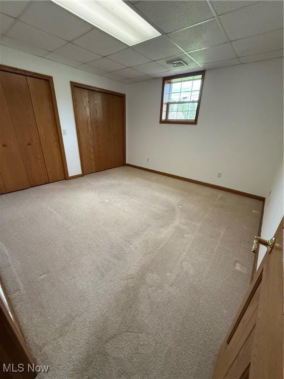 31 Briar Ln, Millersburg, OH 44654 - unfurnished bedroom featuring multiple closets, light colored carpet, baseboards, visible vents, and a paneled ceiling