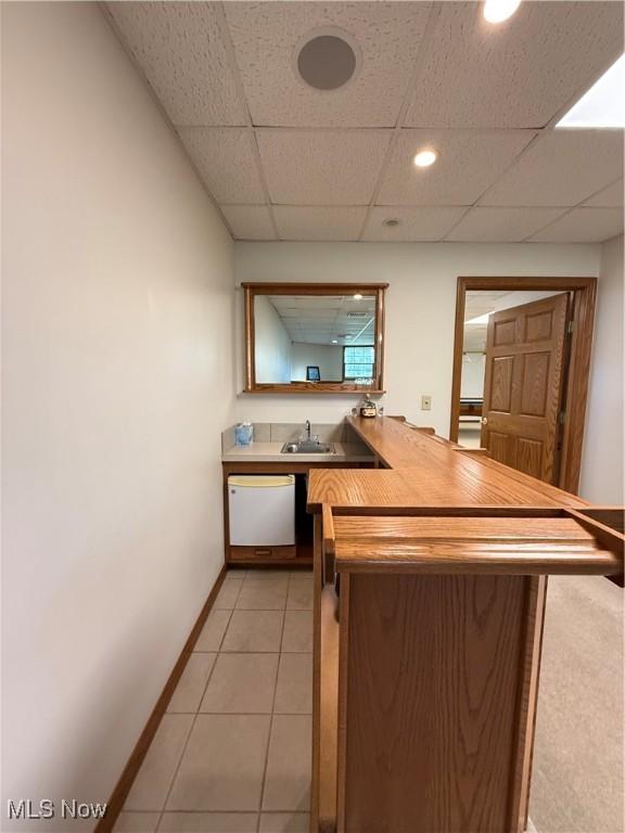 31 Briar Ln, Millersburg, OH 44654 - kitchen featuring white dishwasher, a sink, light tile patterned flooring, baseboards, and a peninsula