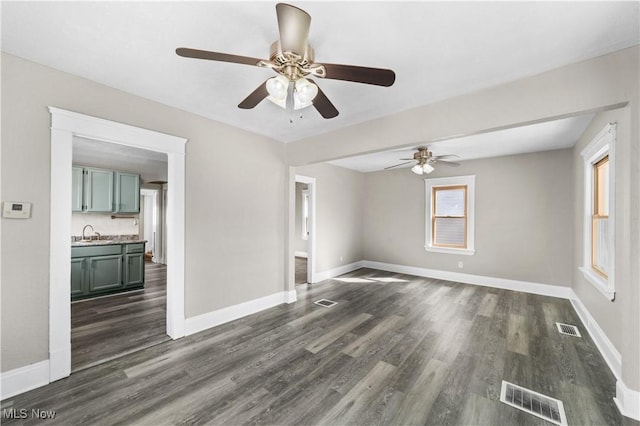unfurnished room with dark wood finished floors, visible vents, and a sink