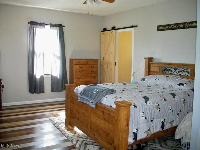 8045 State Route 555, Cutler, OH 45724 - bedroom featuring baseboards, a ceiling fan, a barn door, and wood finished floors