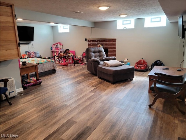 145 Maplewood Ave, Rittman, OH 44270 - rec room featuring a fireplace, wood finished floors, and a textured ceiling